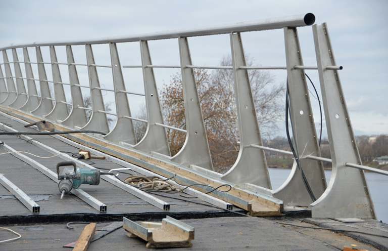 На пешеходном мосту через Тьмаку в Твери устанавливают перила и укладывают покрытие